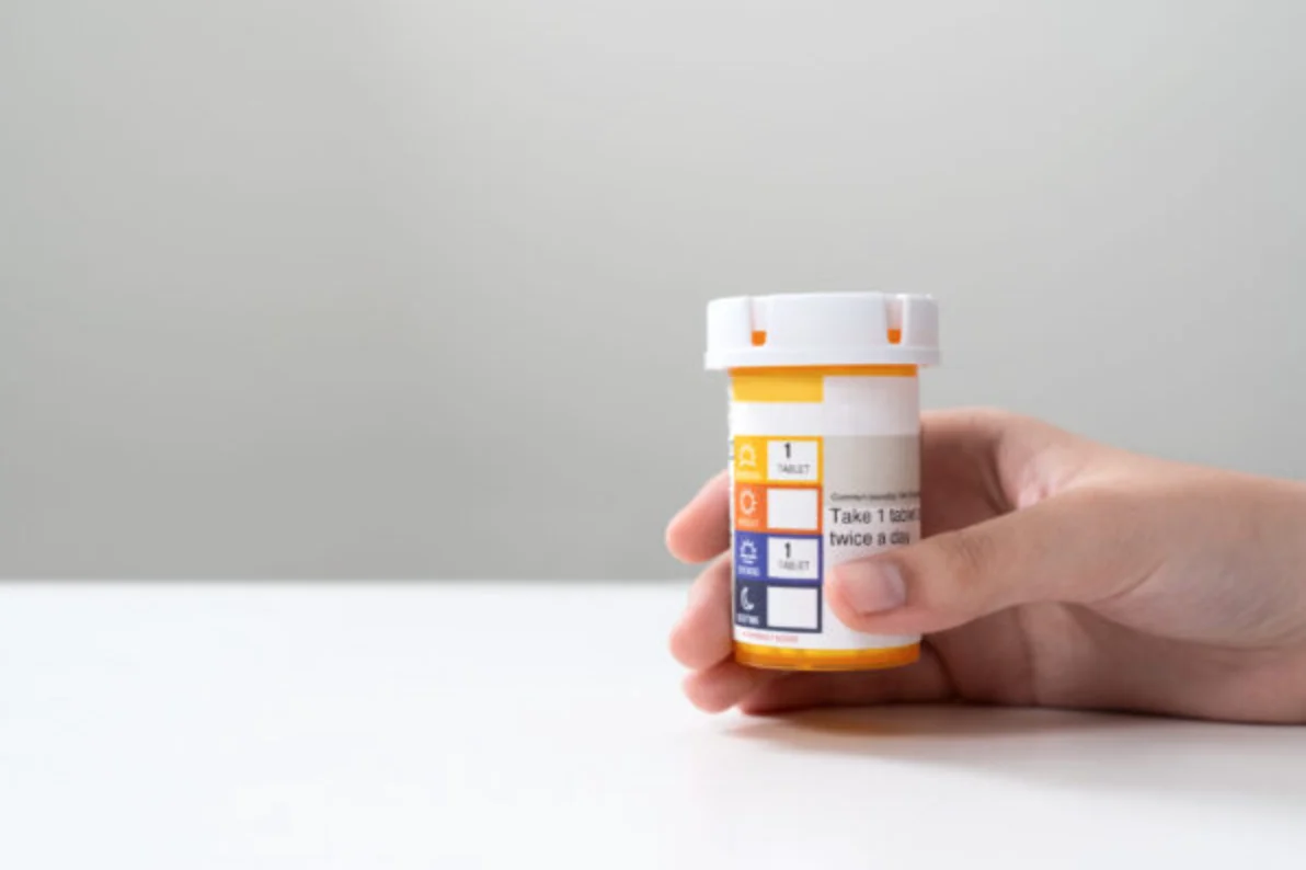 Hand hold an orange color pill bottle, concept for healthcare, medicine, pharmacy and prescription